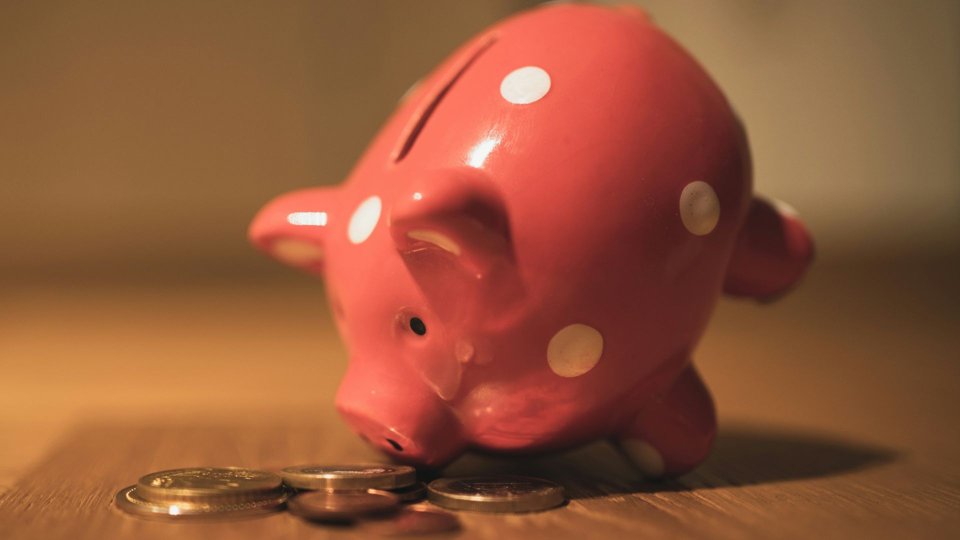 pink pig coin bank on brown wooden table