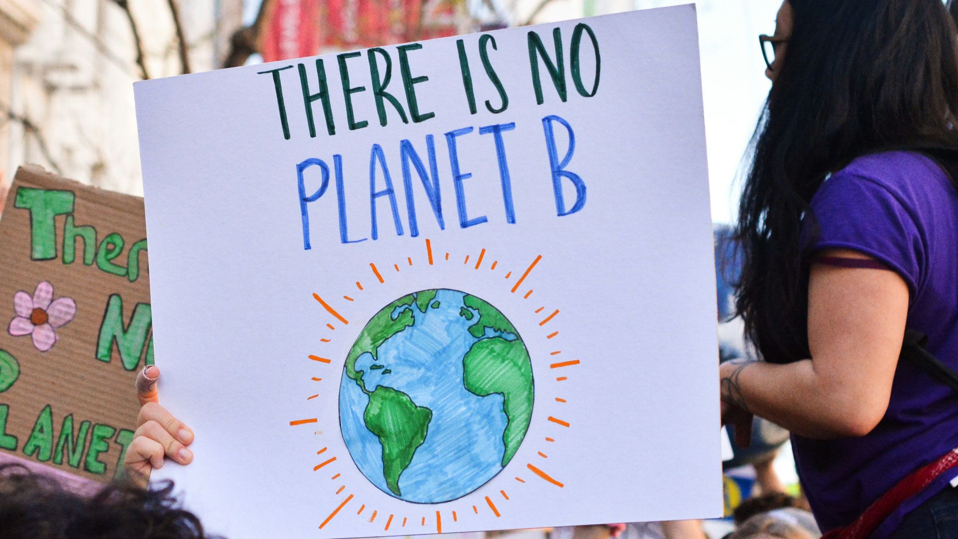 person holding there is no planet b poster
