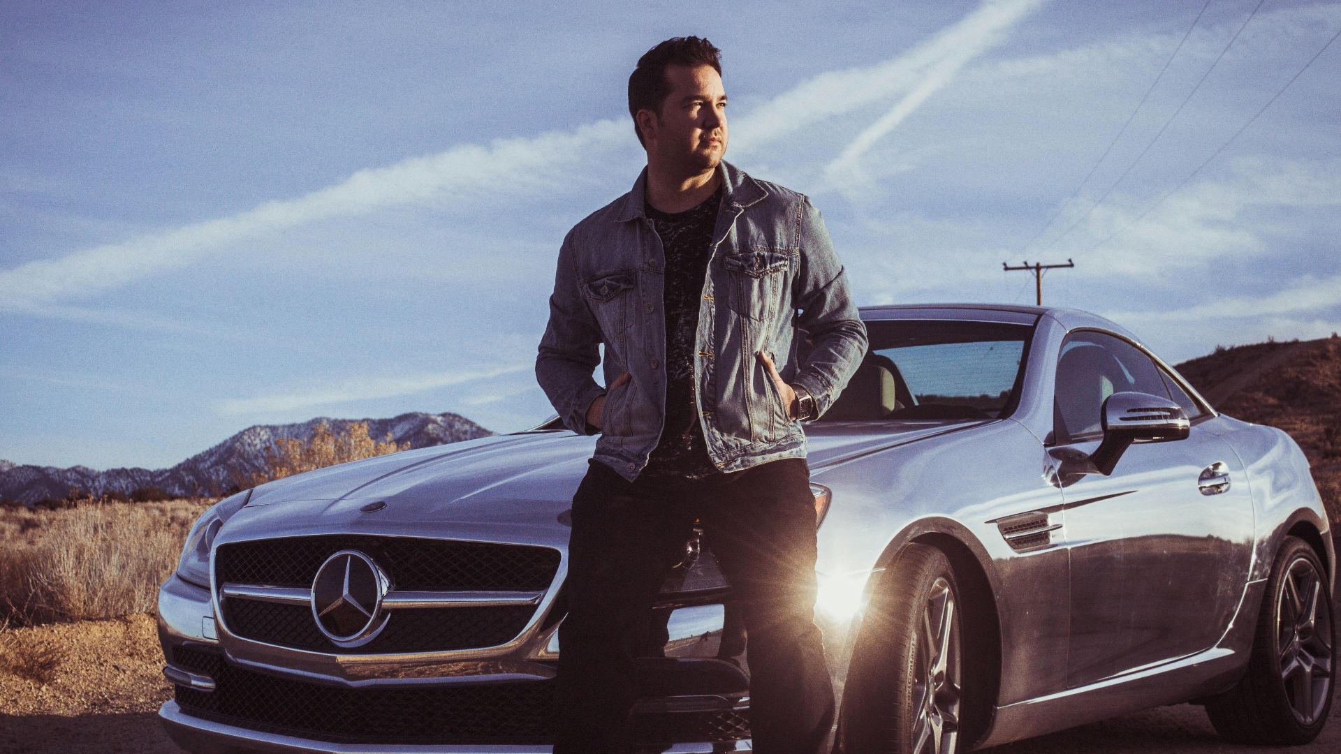man sitting on Mercedes-Benz car's hood