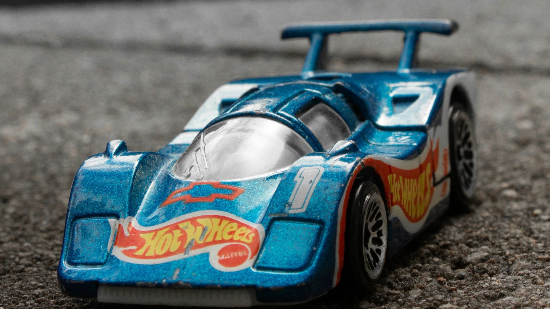 a blue toy car sitting on top of a street
