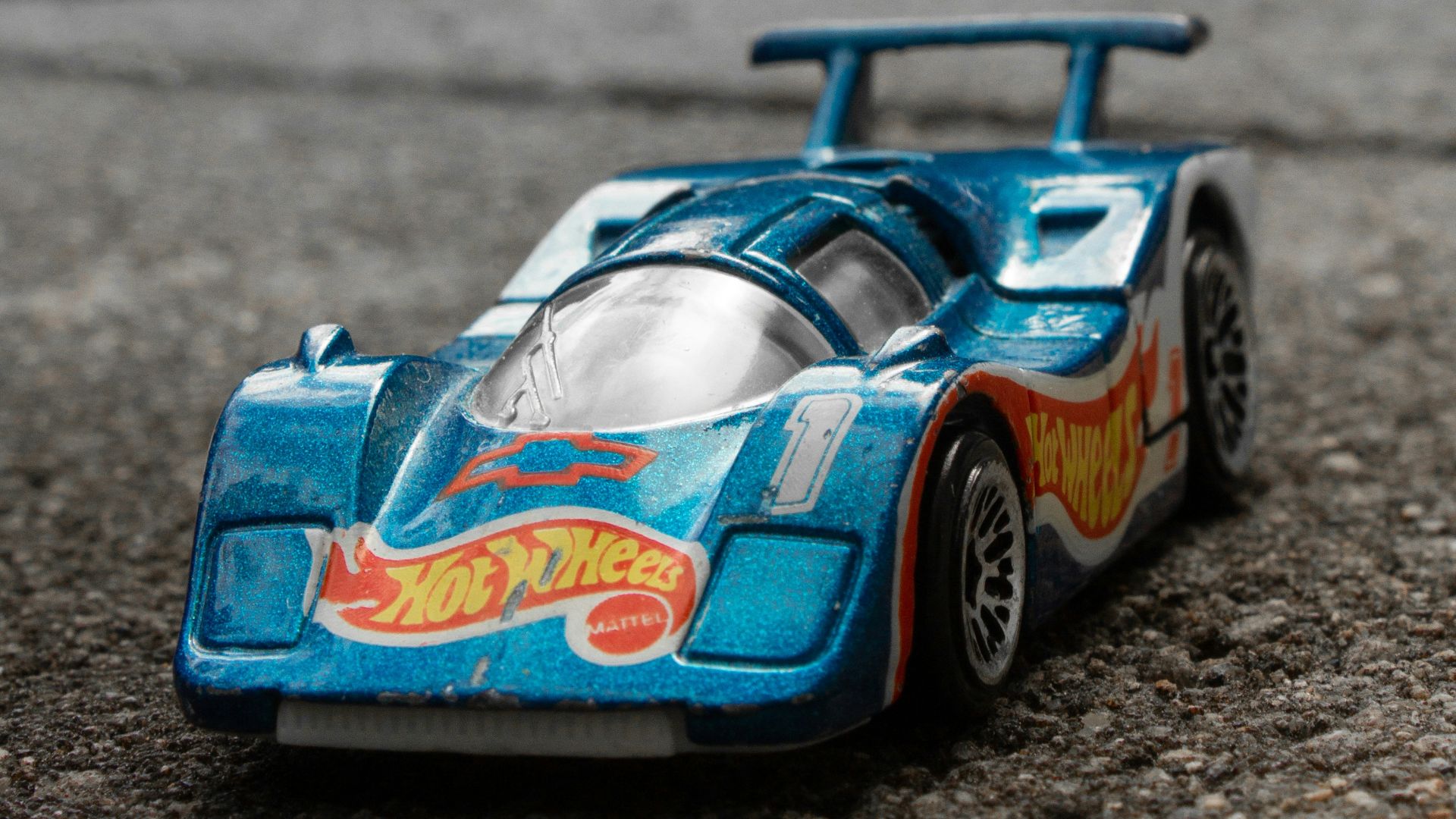 a blue toy car sitting on top of a street