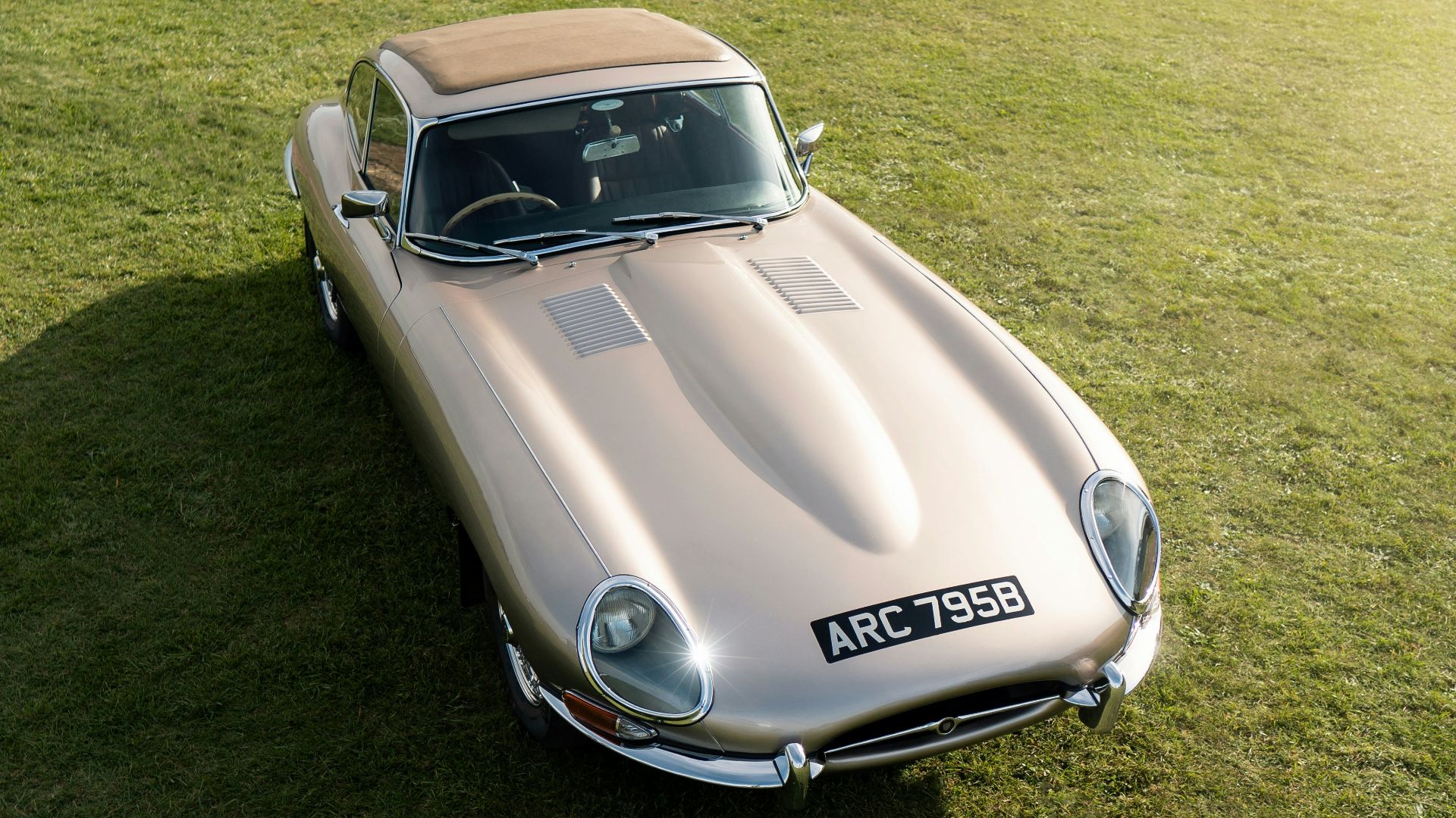 A silver car parked on top of a lush green field
