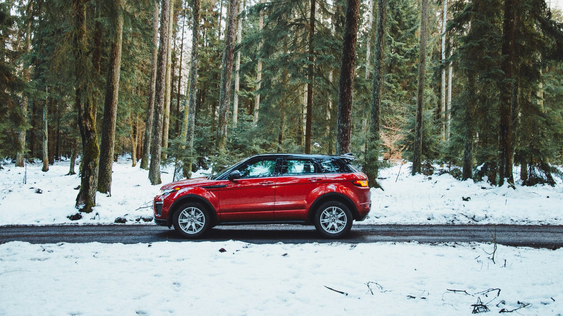 red suv on snow covered road during daytime