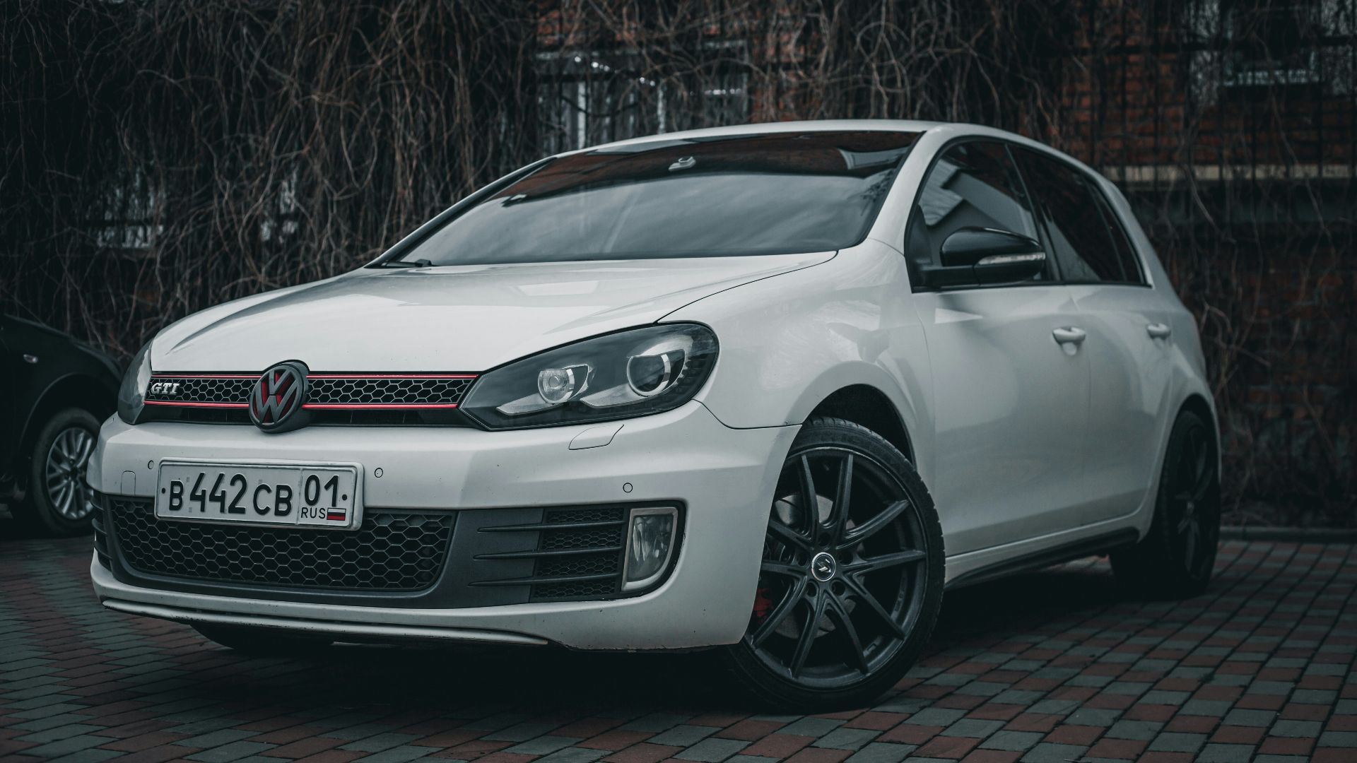 a white car parked in front of a brick building