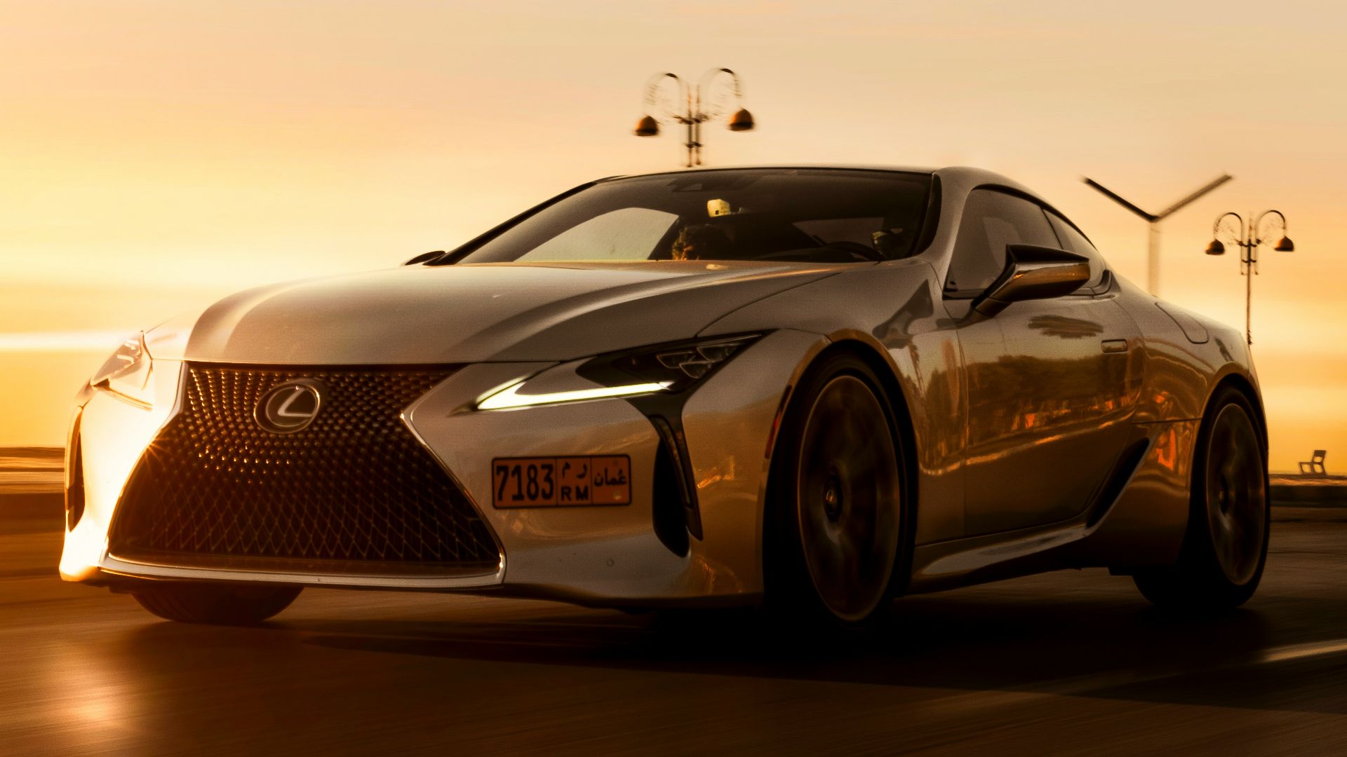 a silver sports car driving down a road