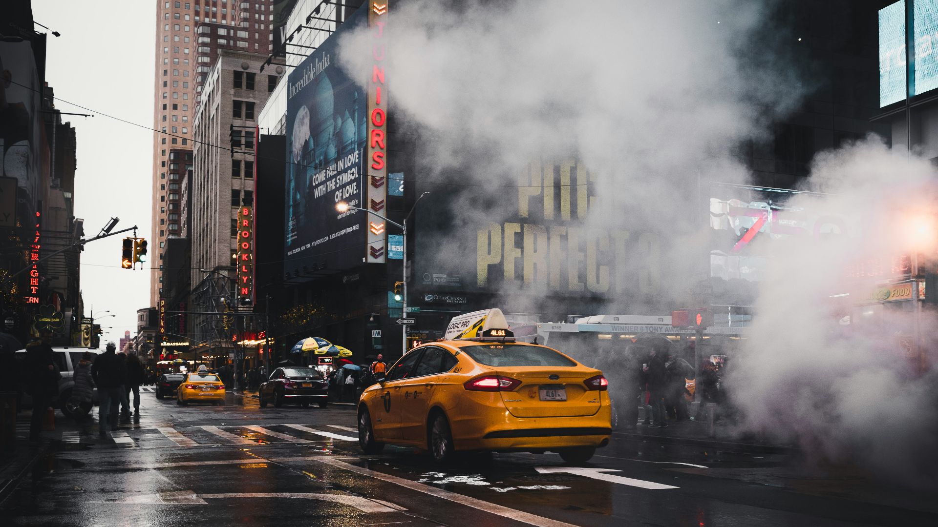 yellow taxi sedan on gray concrete street passed through white smokes near walking lane