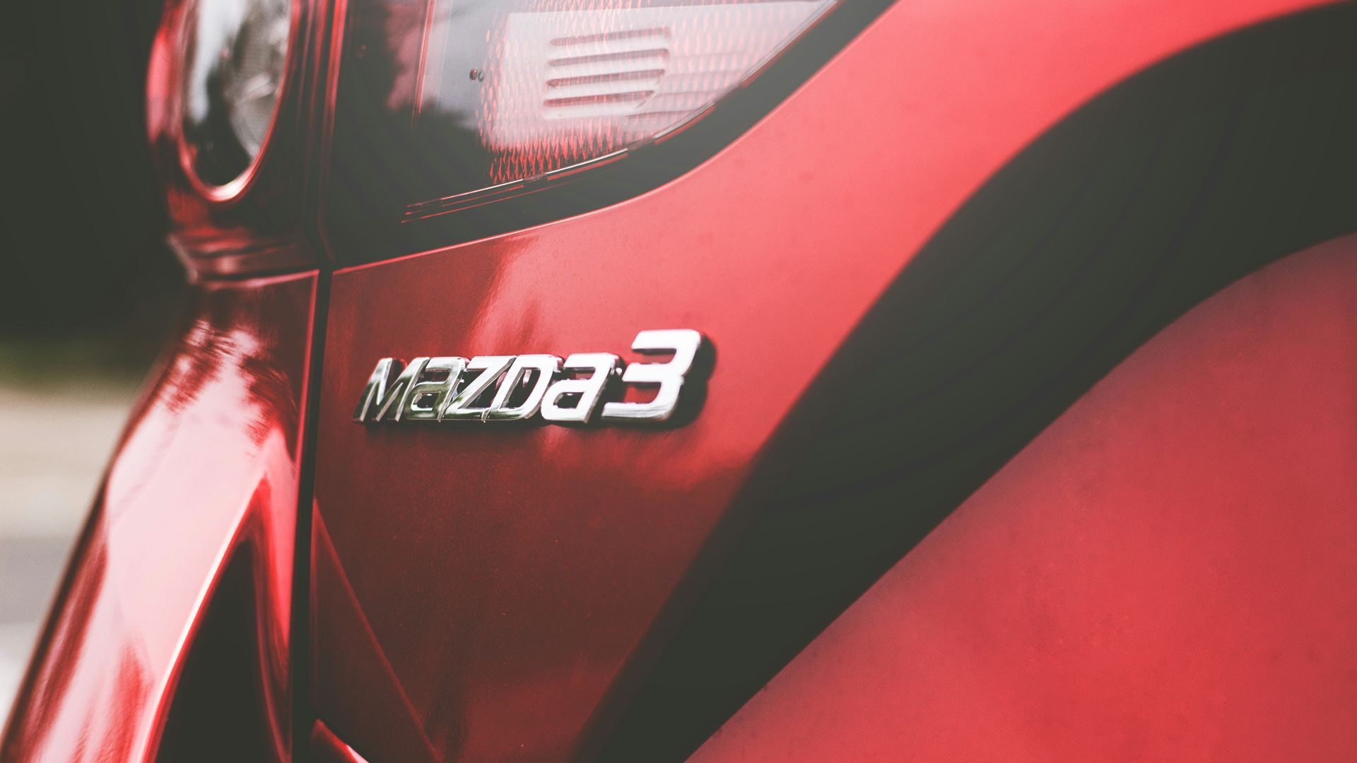 closeup photography of red Mazda 3 vehicle