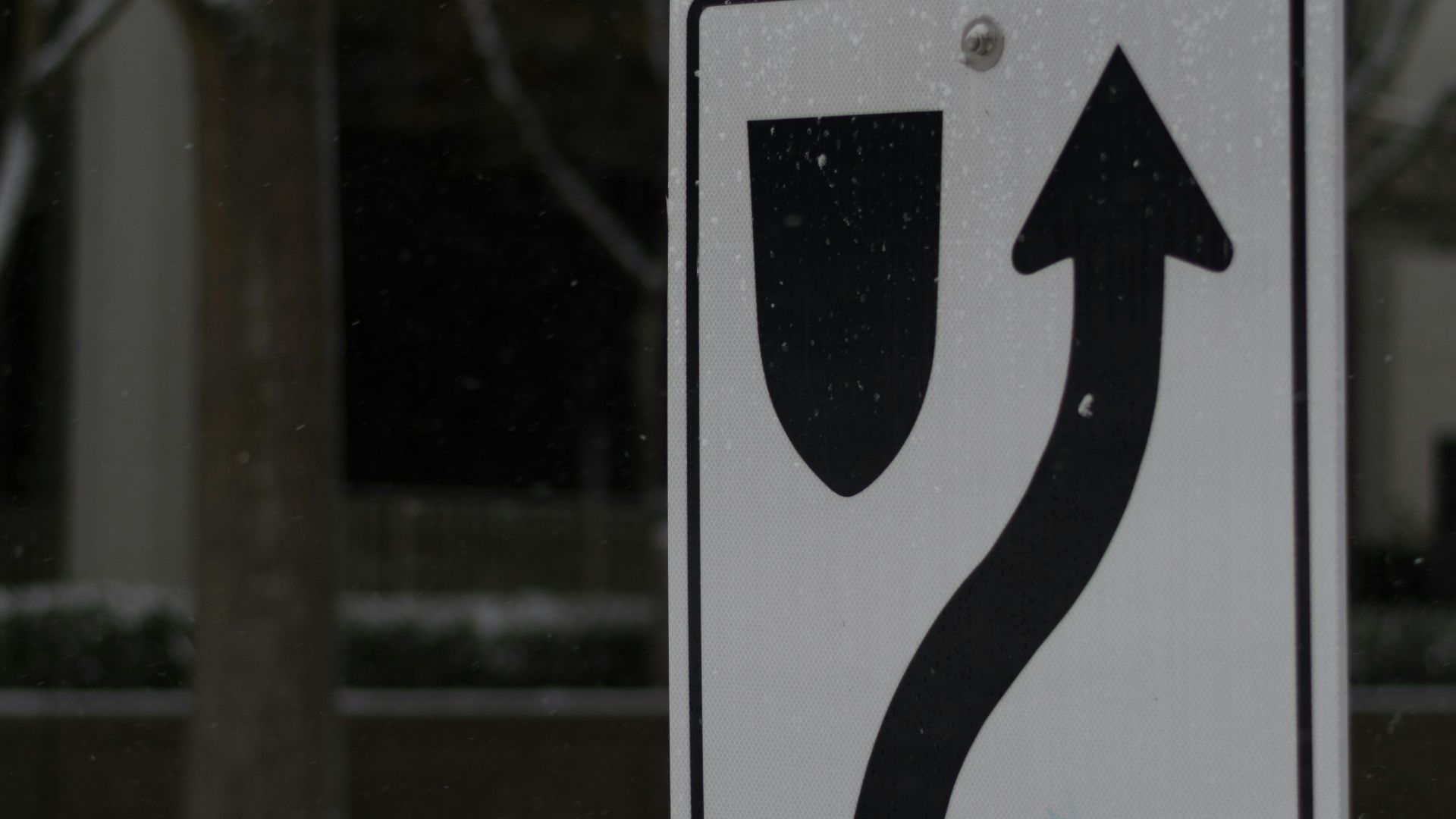 a street sign on a pole in the snow