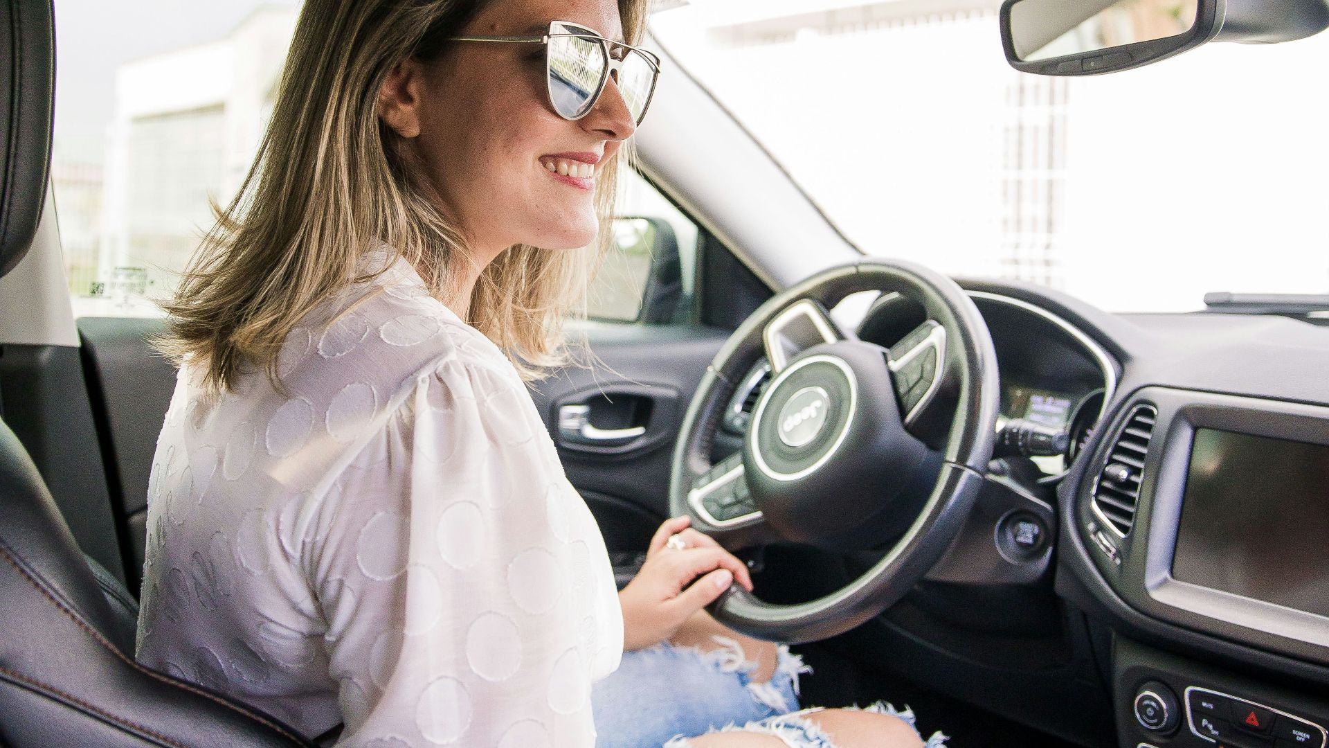 woman in white long sleeve shirt driving car