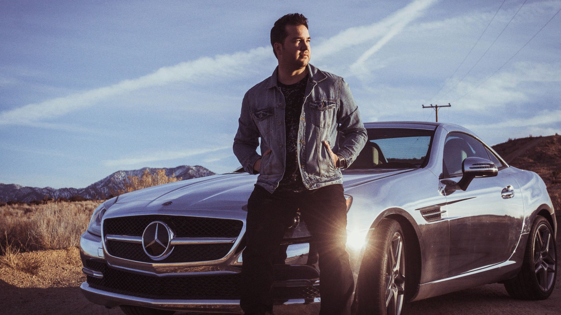 man sitting on Mercedes-Benz car's hood