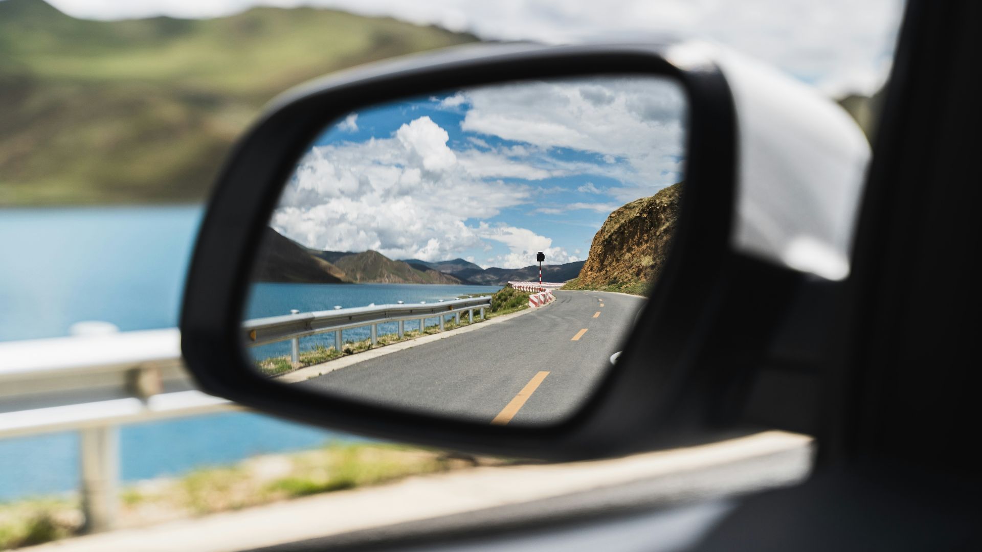 car side mirror showing city buildings during daytime