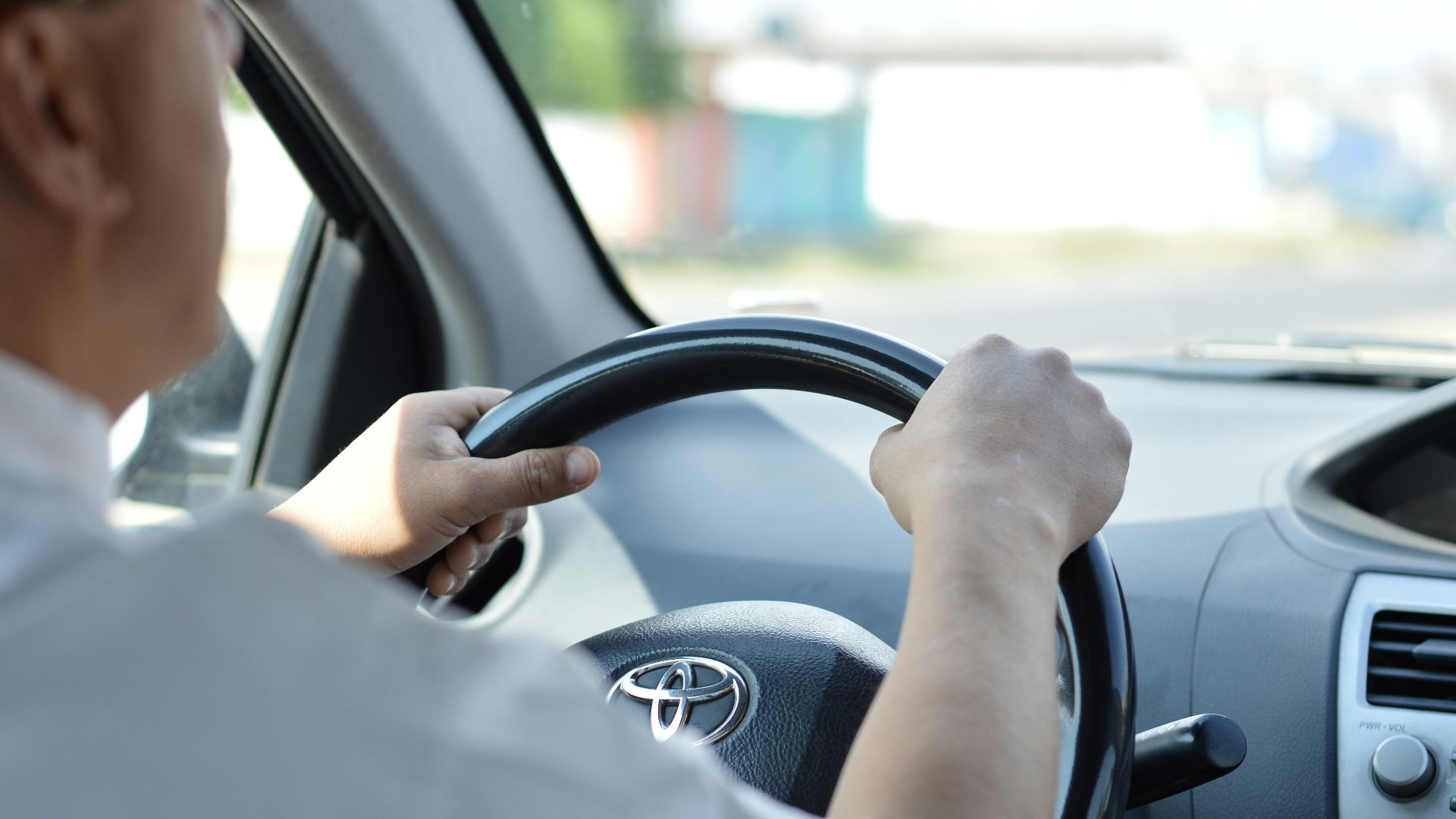 person in white long sleeve shirt driving car