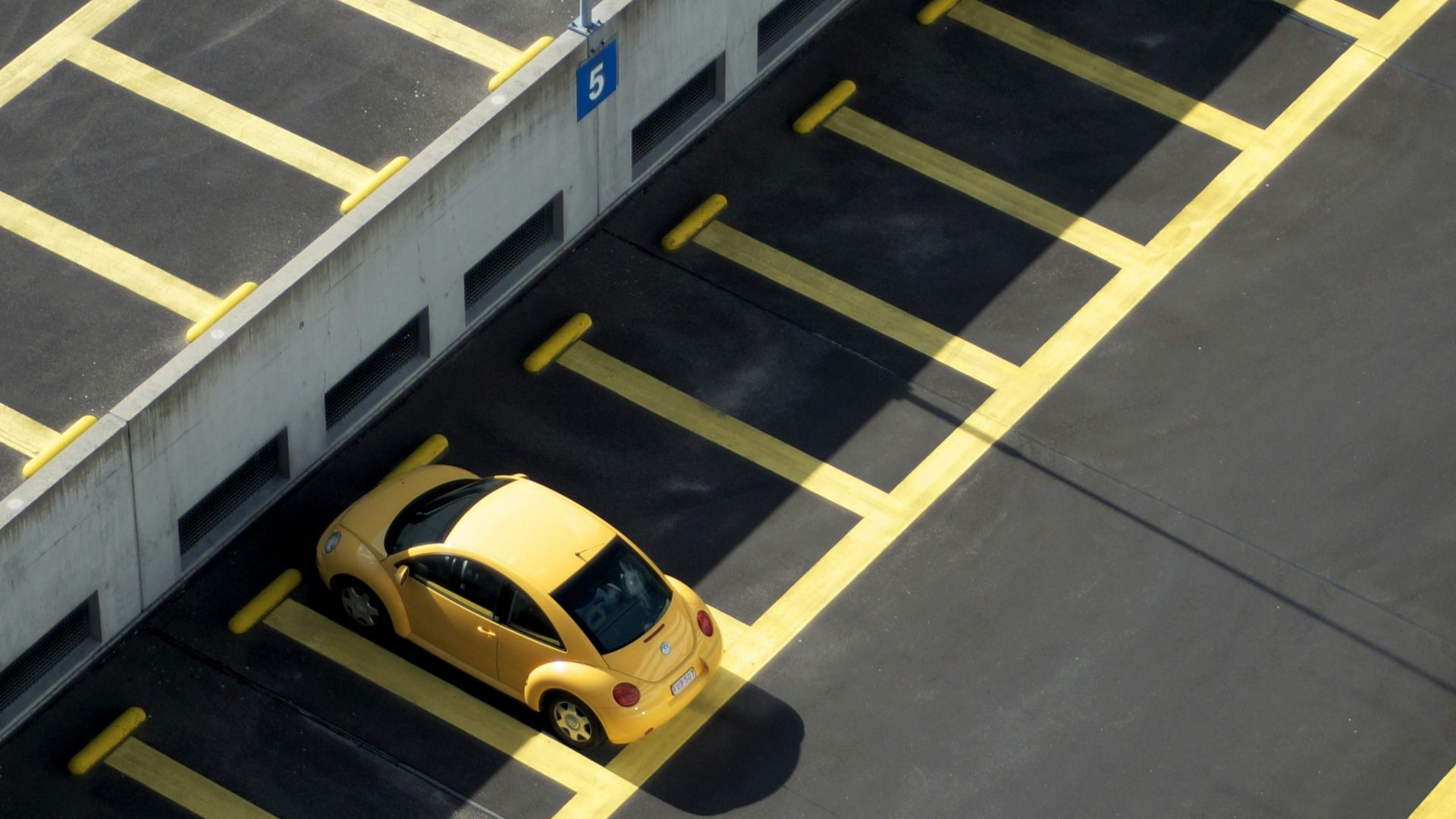 yellow coupe on parking lot at daytime
