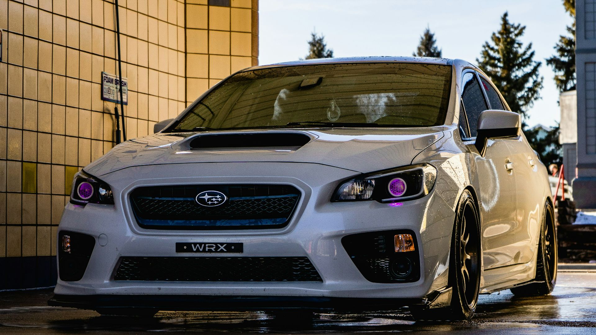white honda car parked beside brown brick wall