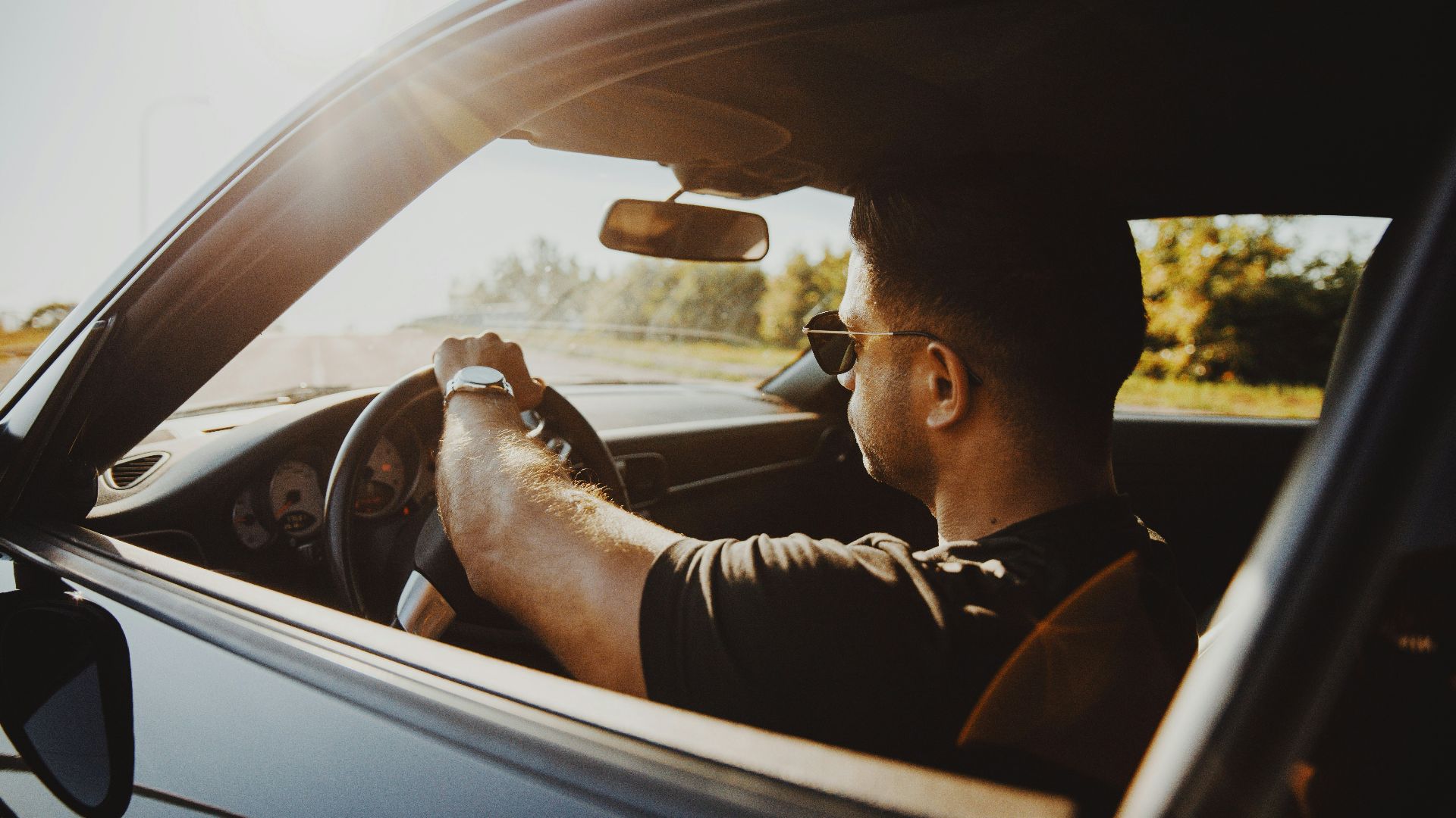 man in black jacket driving car during daytime