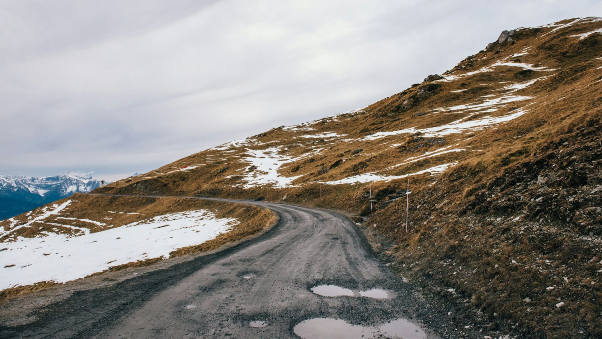 road beside mountain with snow during daytime