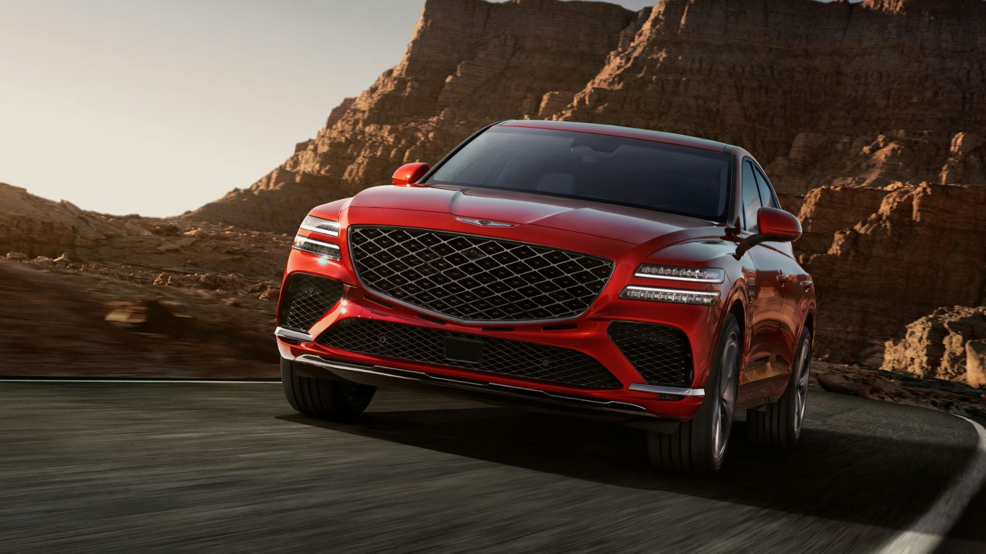 a red mercedes suv driving down a mountain road