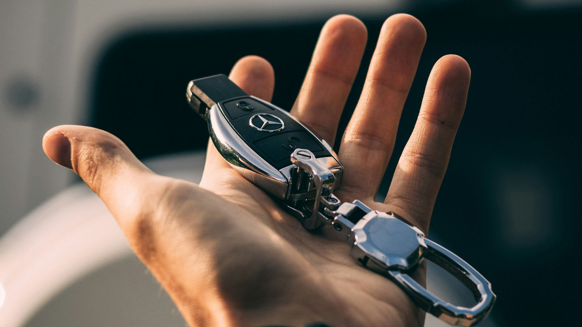 person holding Mercedes-Benz fob
