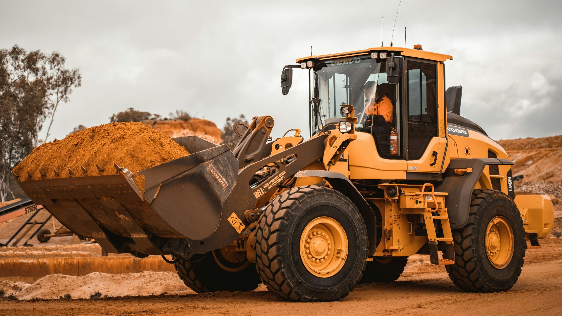 yellow and black heavy equipment on brown field during daytime