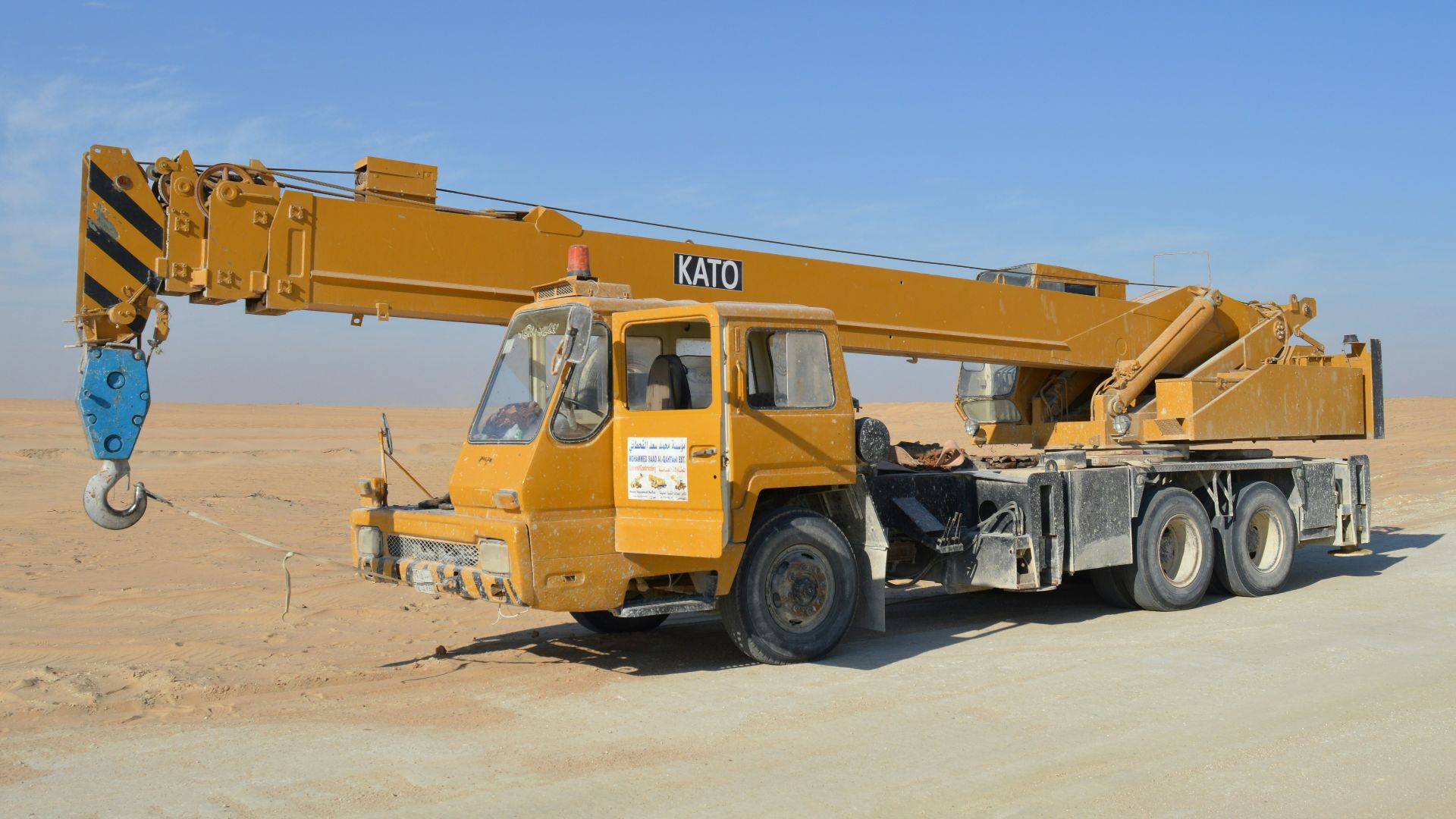 yellow and black excavator on white sand during daytime