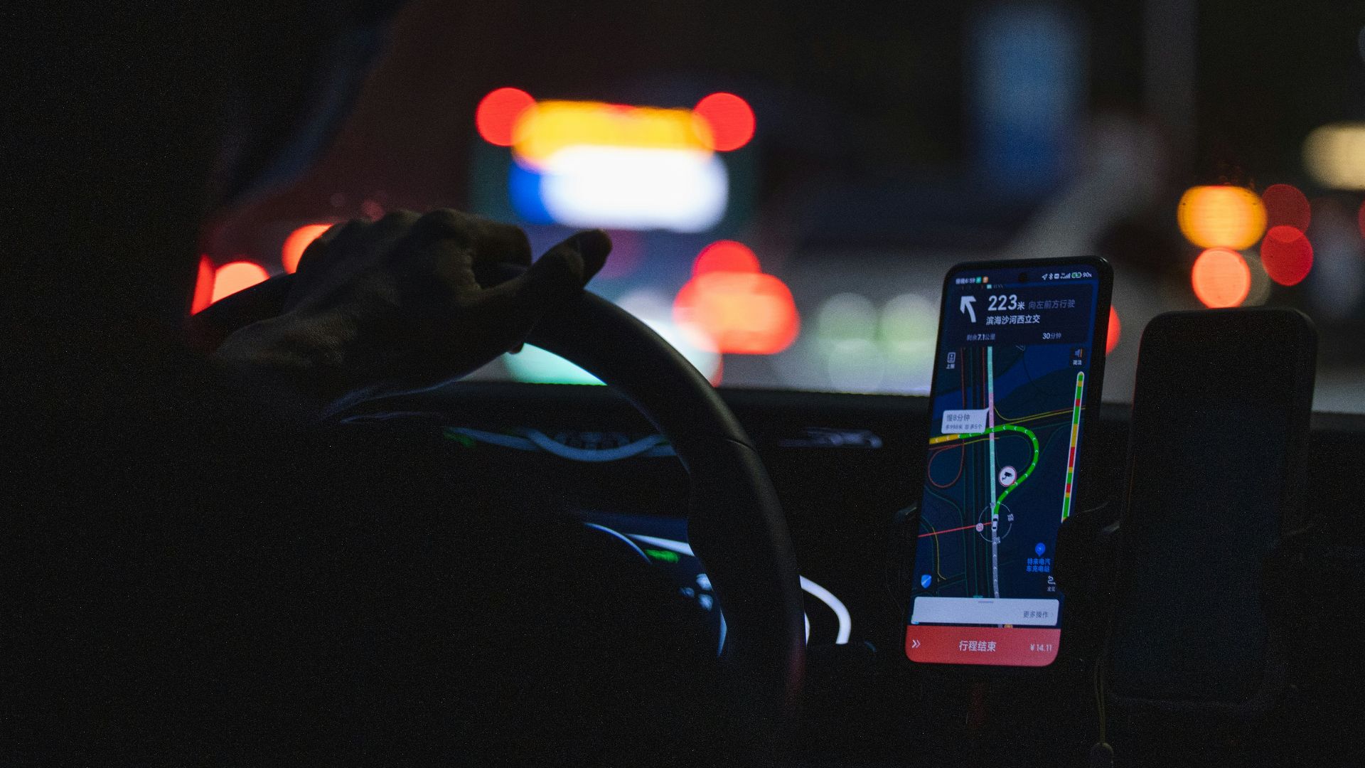 a person driving a car at night with a cell phone