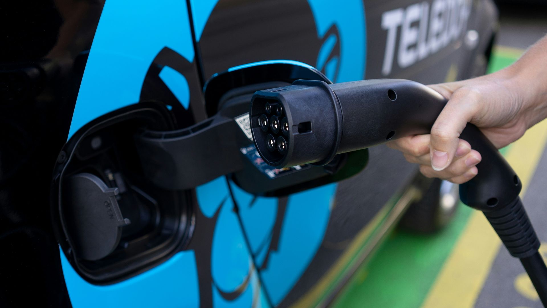 person holding black and blue bicycle helmet