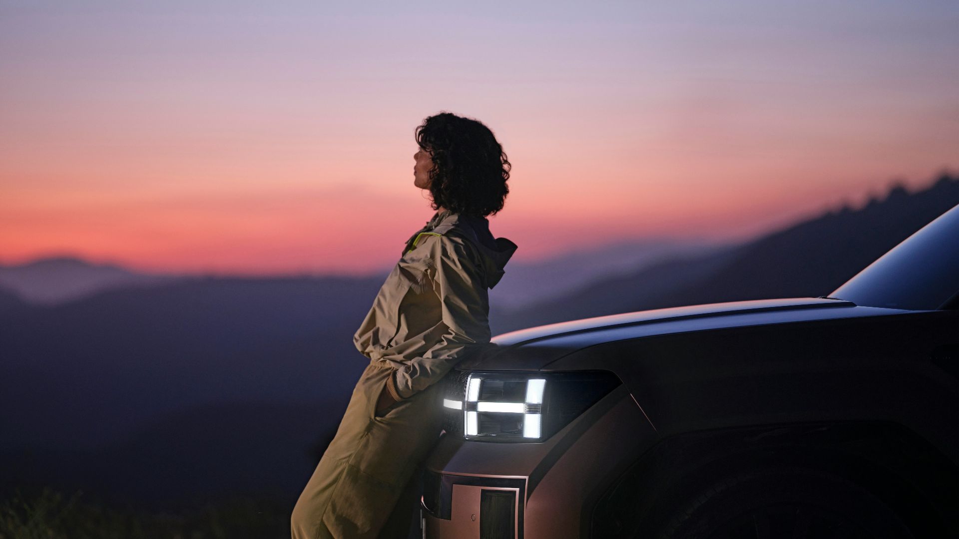 a woman sitting on the hood of a car