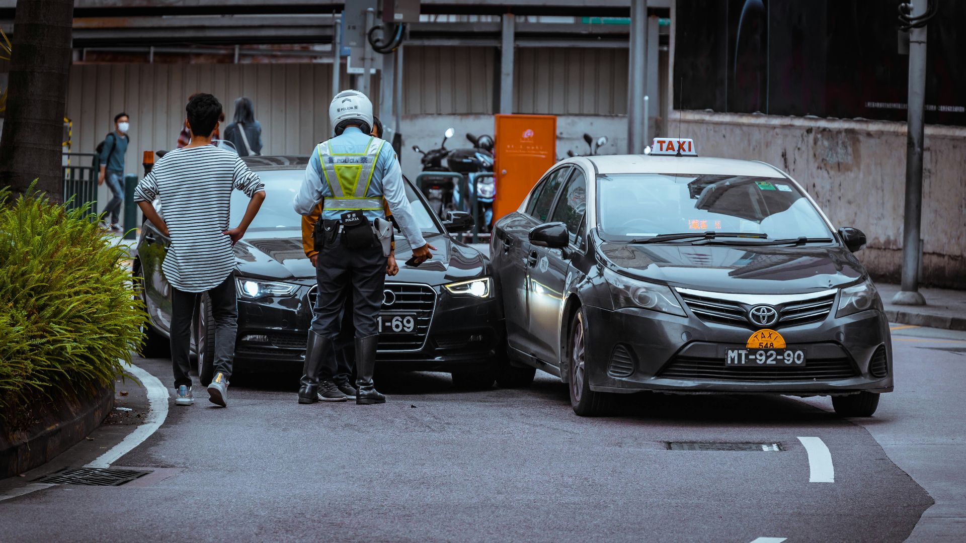 man in white and black stripe shirt and black pants standing beside black car during daytime