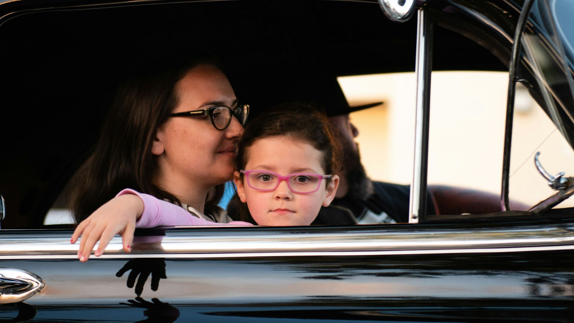 girl and woman inside black car