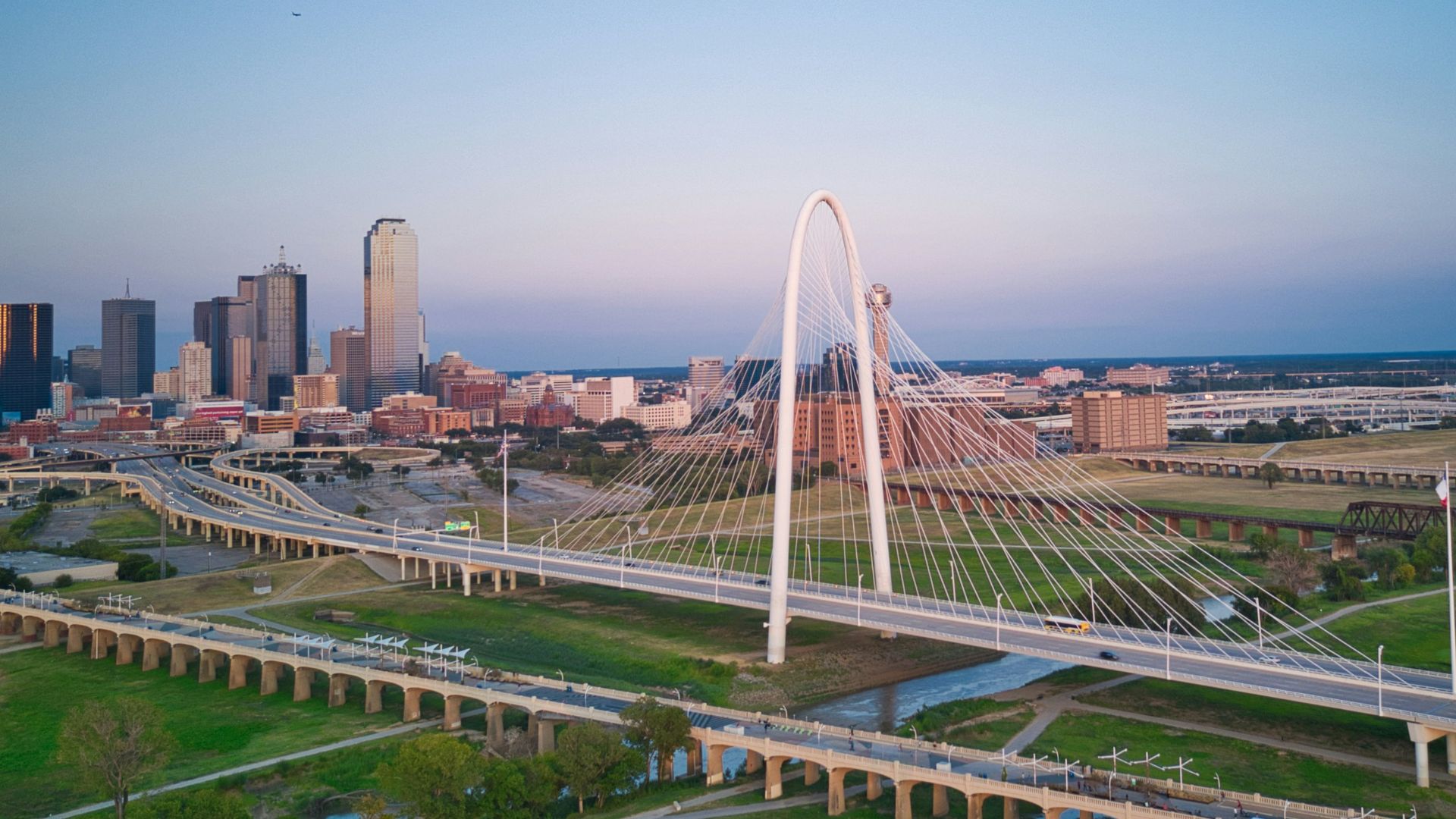 an aerial view of a city with a bridge in the foreground