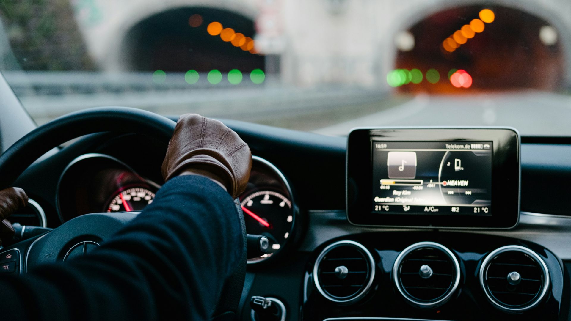 person inside vehicle holding steering wheel