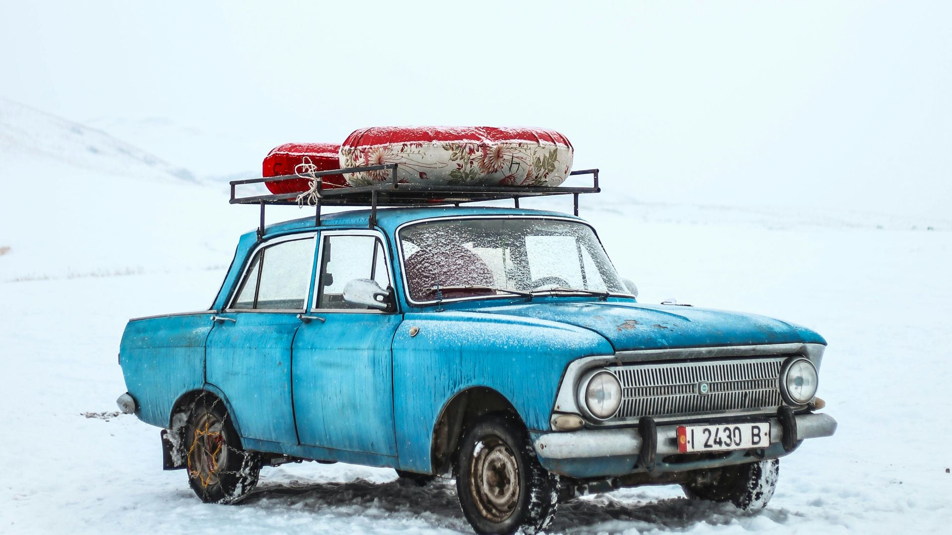 blue sedan on snow ground
