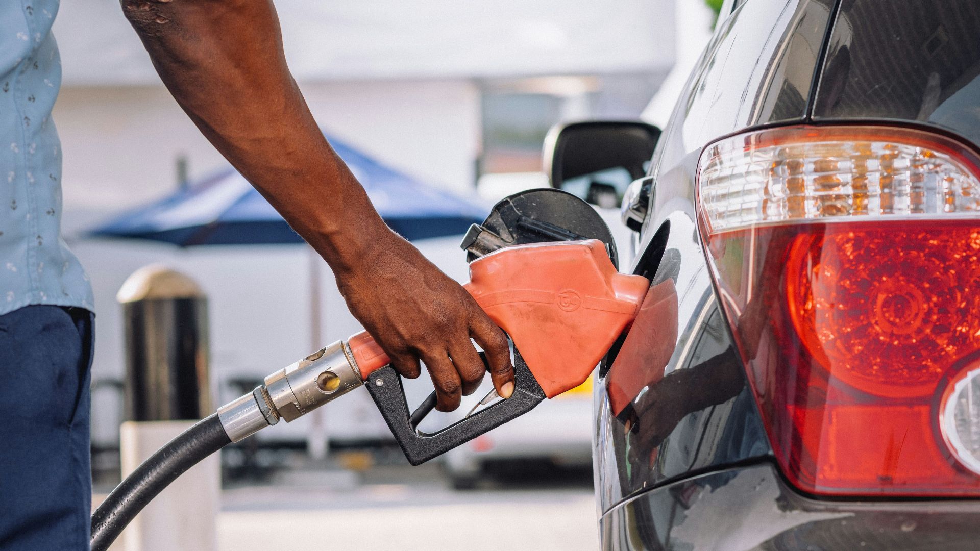 a man pumping gas into his car at a gas station
