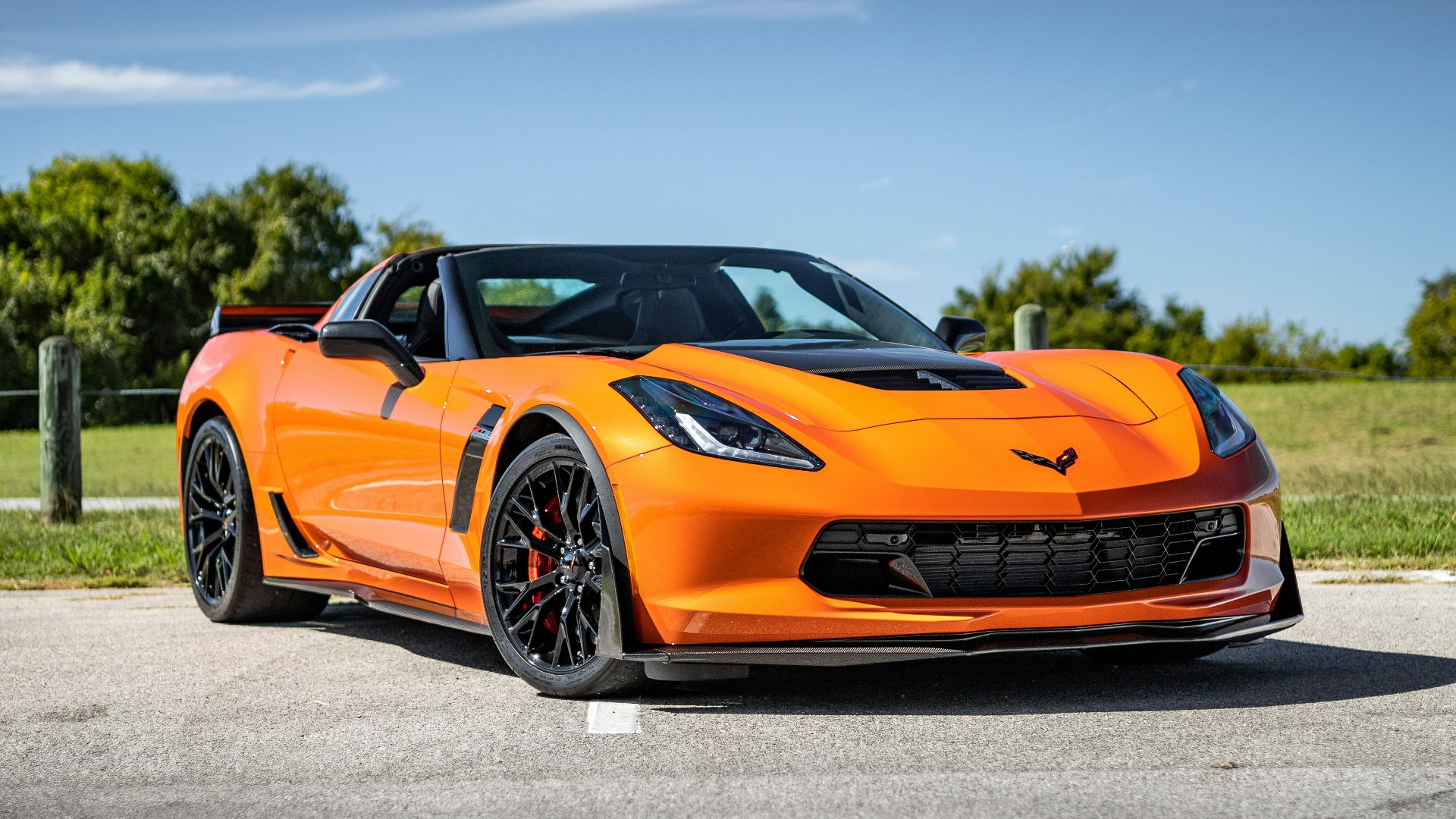 an orange sports car parked on the side of the road