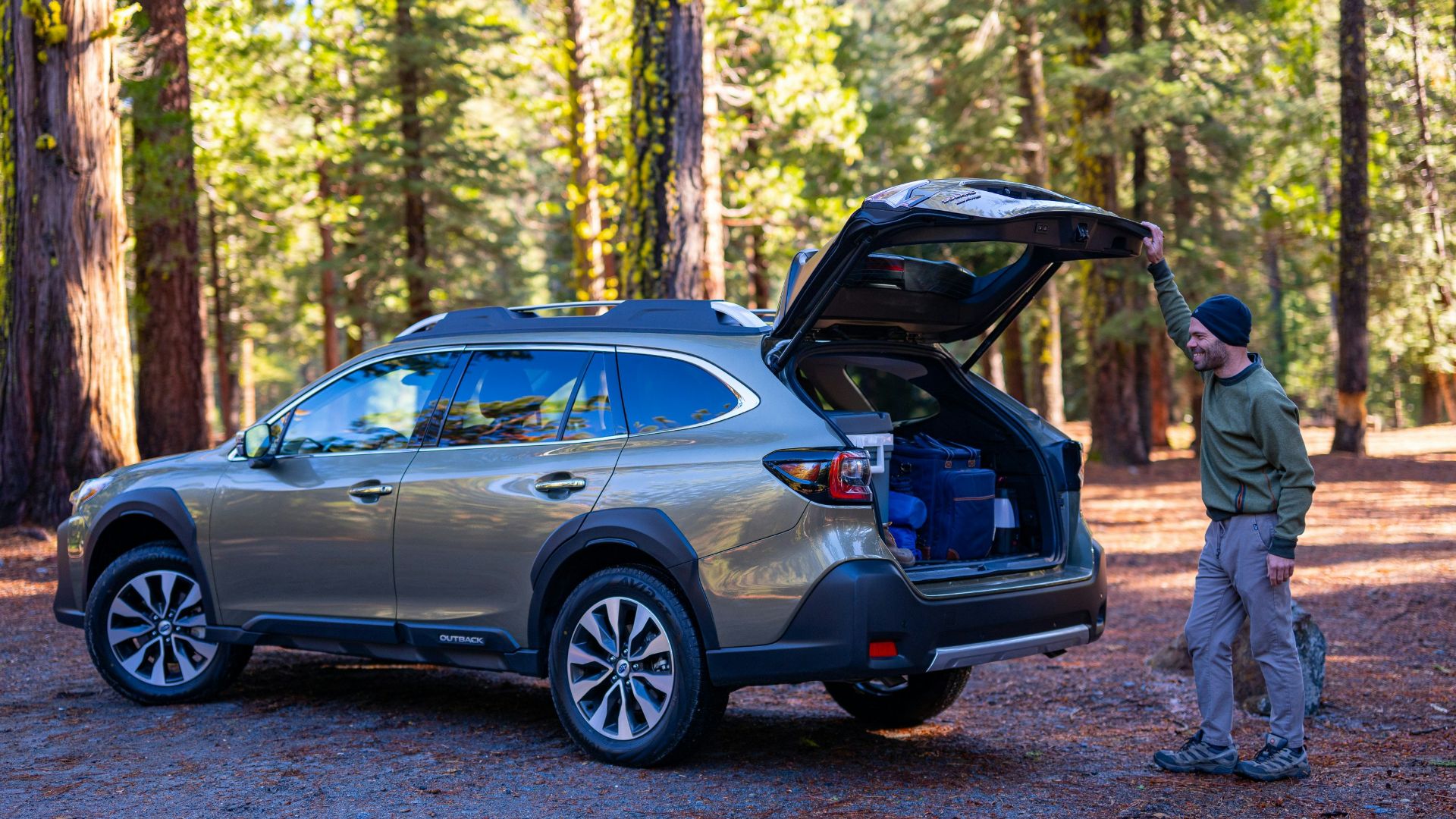 A man standing next to a car with its trunk open