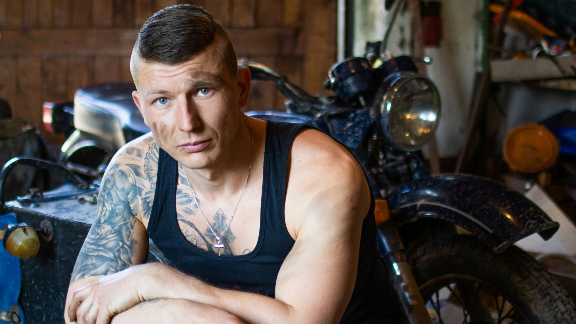 man in black tank top sitting on motorcycle