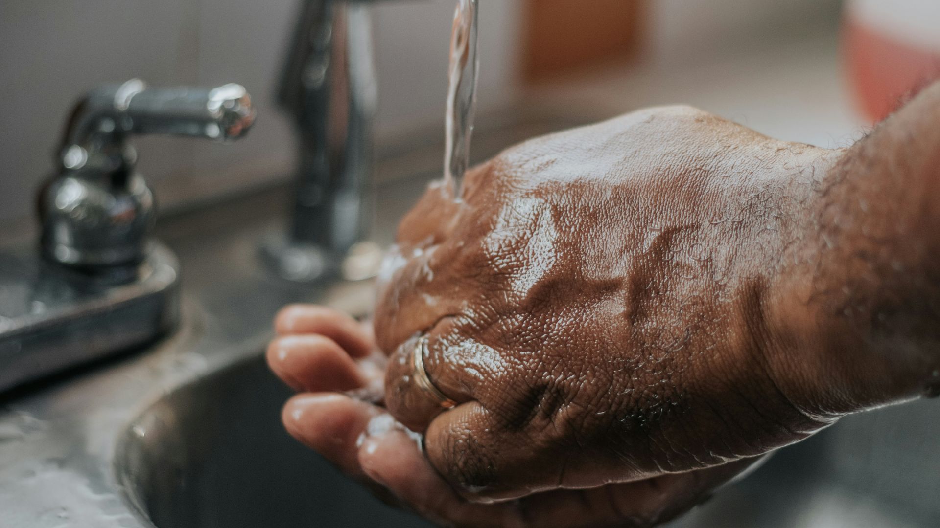 person washing hands on sink