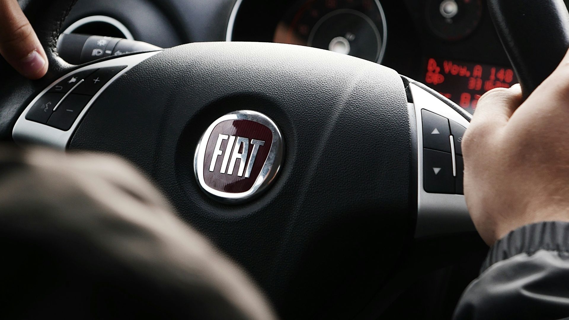 person riding FIAT car during daytime
