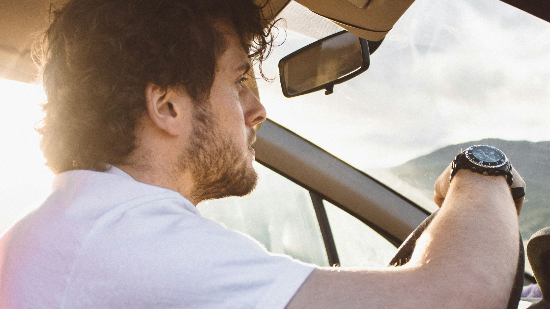 man holding steering wheel