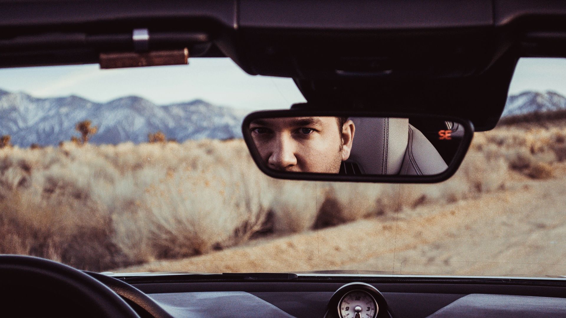 person staring at rear view mirror