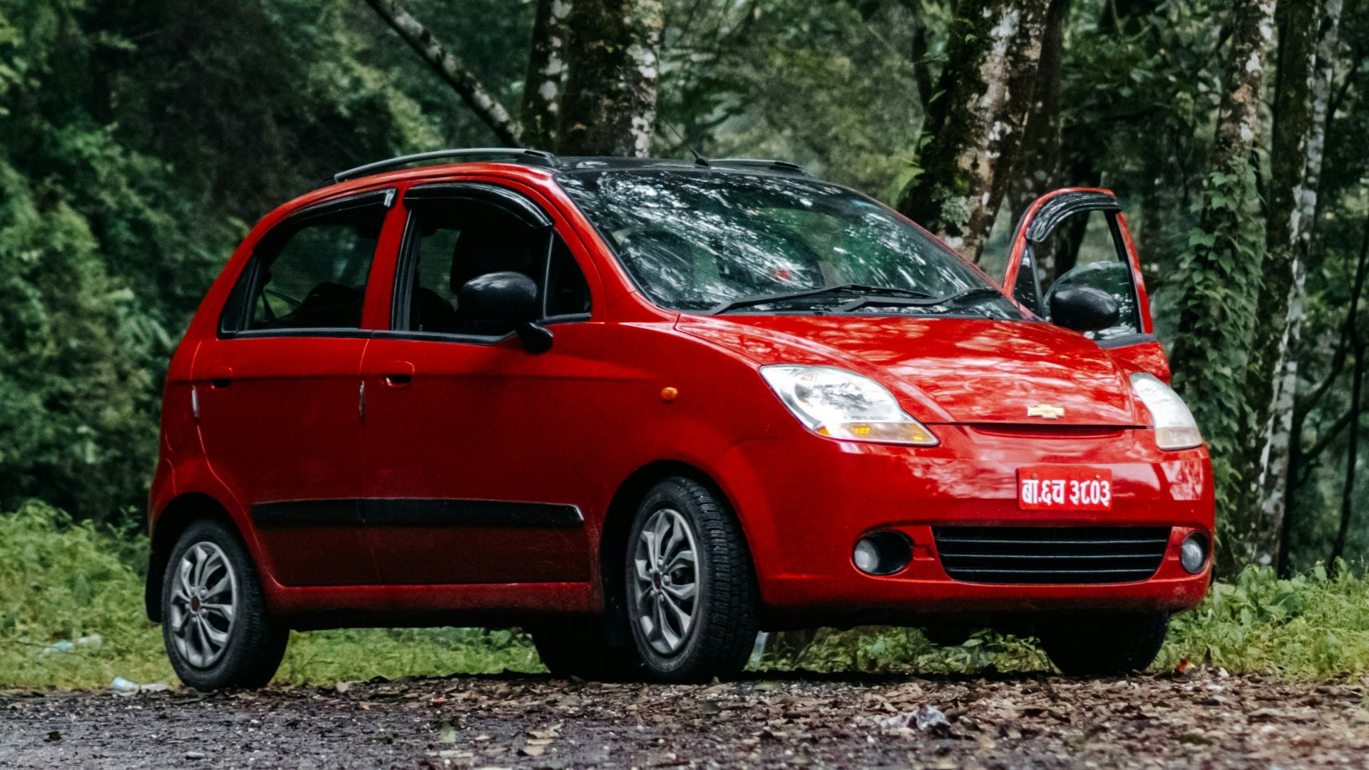 a small red car parked on the side of a road