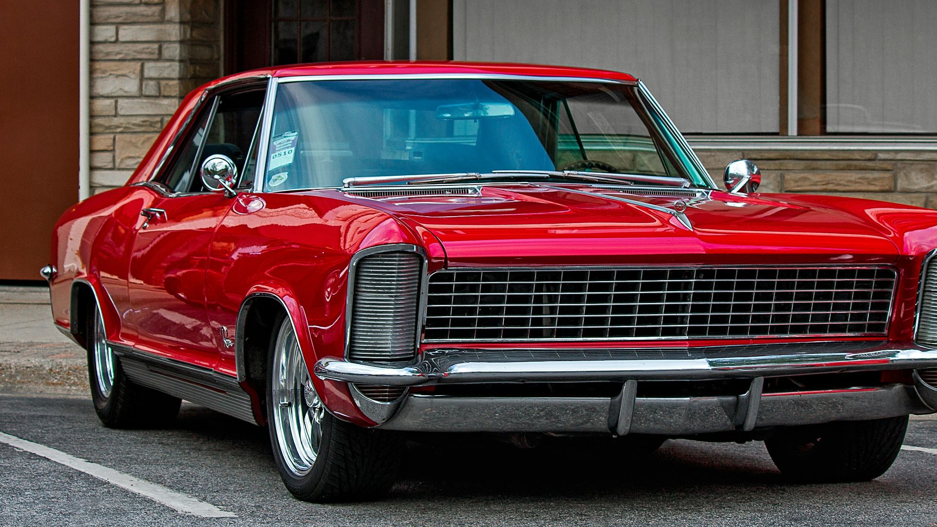 red chevrolet camaro parked in front of building