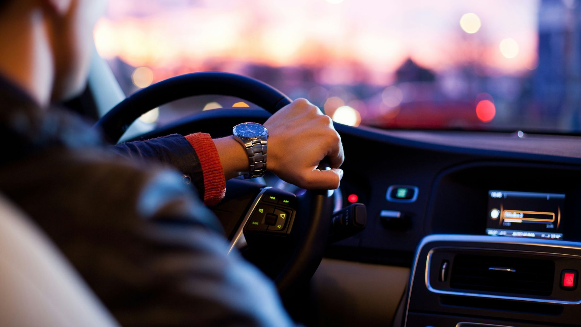 man driving a car wearing wrist watch