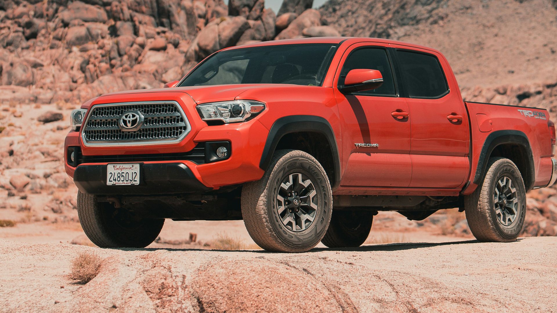 red chevrolet crew cab pickup truck on brown sand