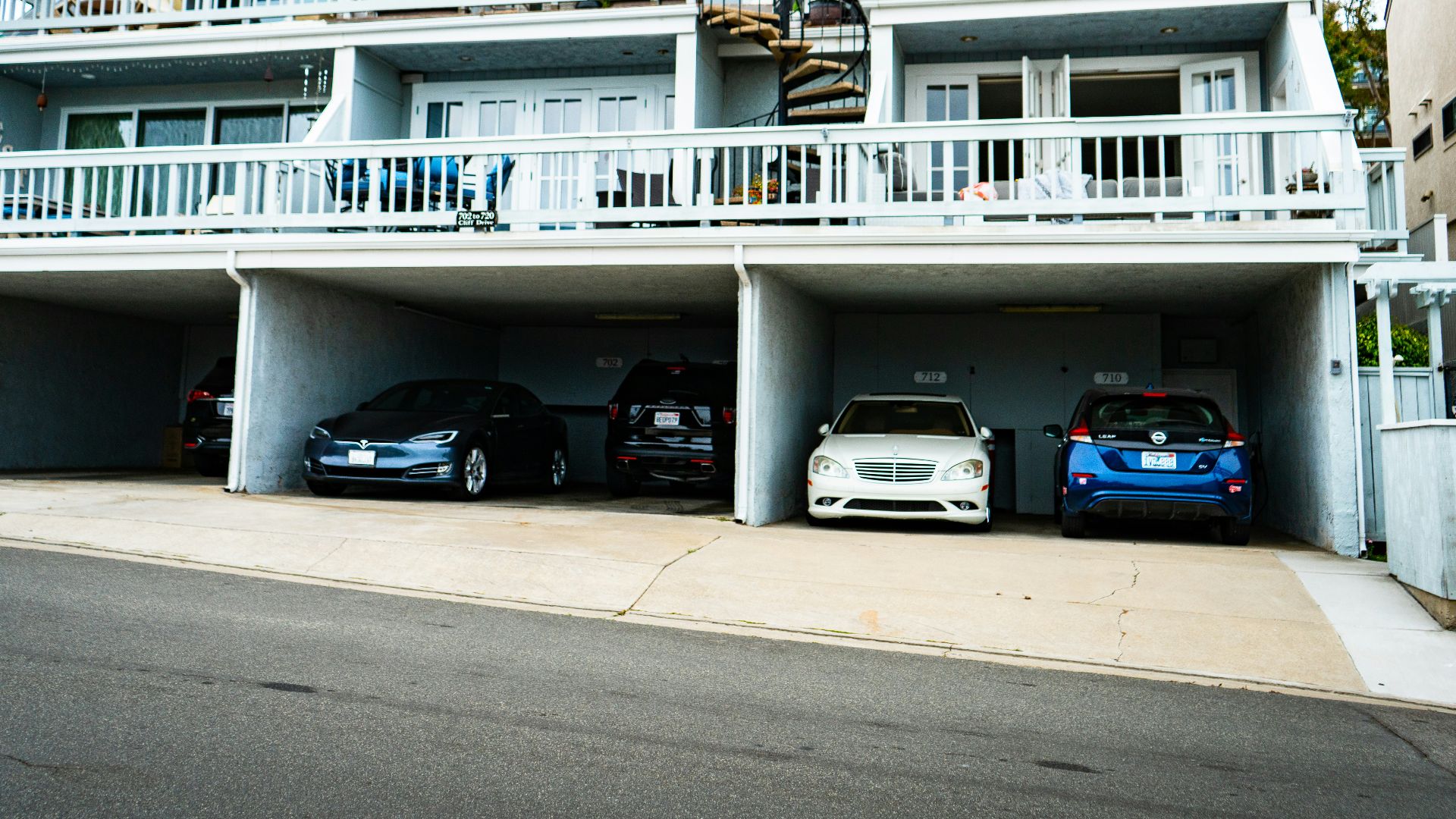 white concrete building with blue car on road during daytime