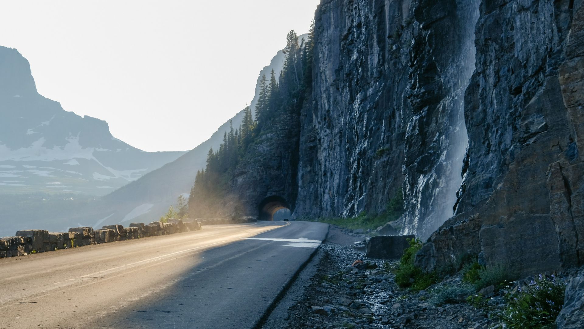 A car driving down a road next to a mountain