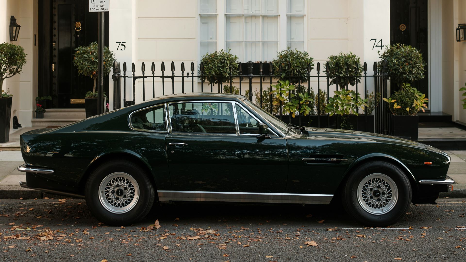 A black car parked in front of a white building