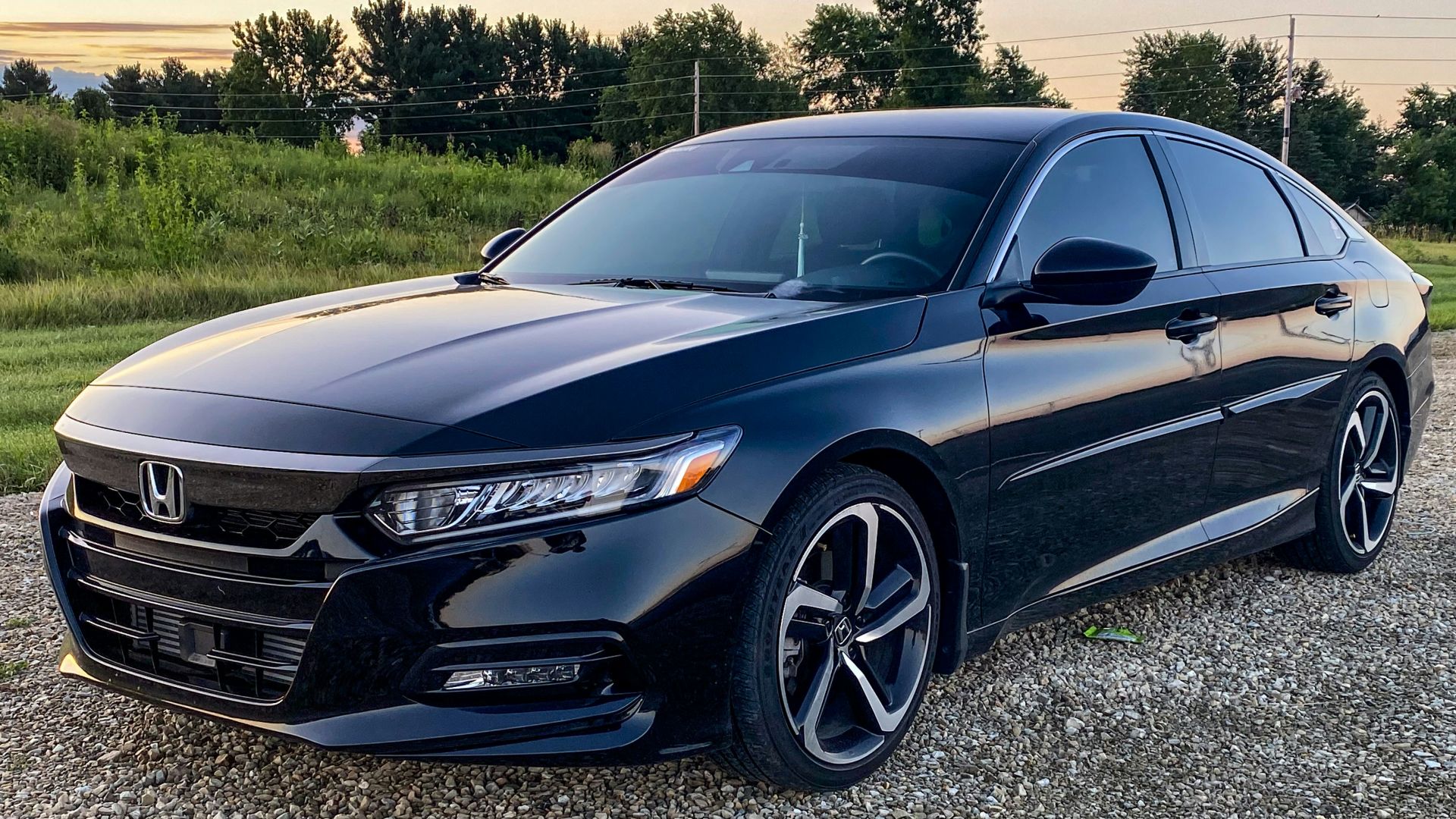 a black car parked on a gravel road