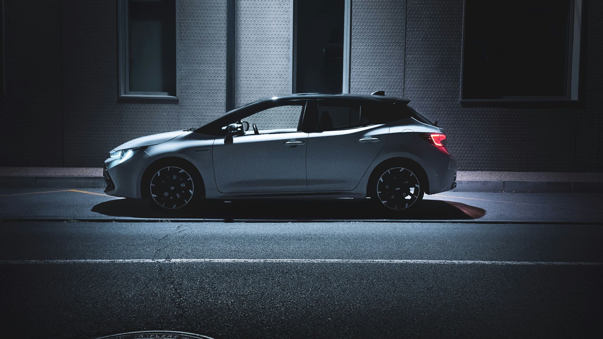 A car parked on the side of the road at night
