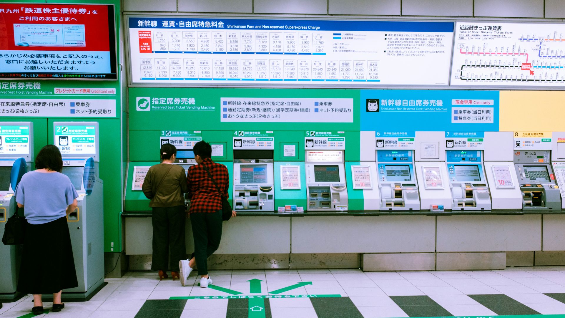 man in black jacket standing near green and white wall